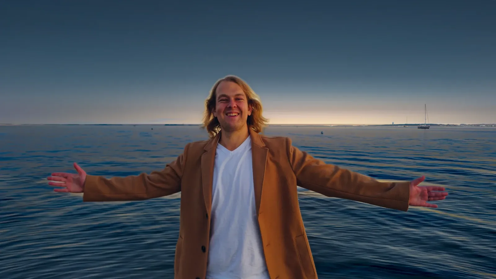 AZADA mit weit geöffneten Armen am Wasser bei Sonnenuntergang