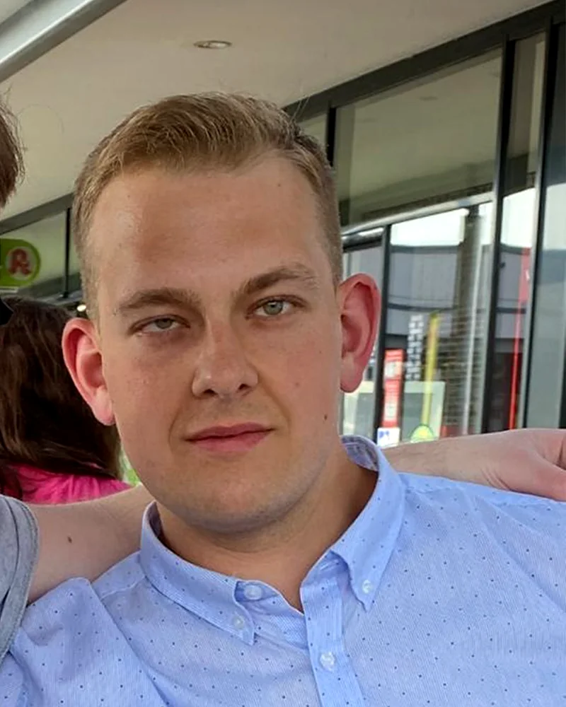 Arnold as a young man in a light blue shirt